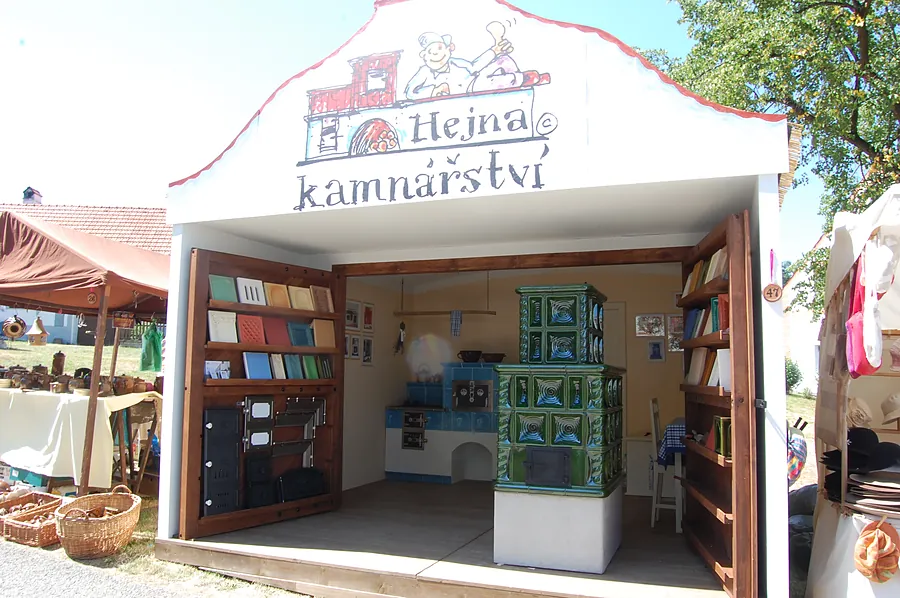 Stánek Hejna kamnářství s ukázkou kachlů a rozestavěnými kamny